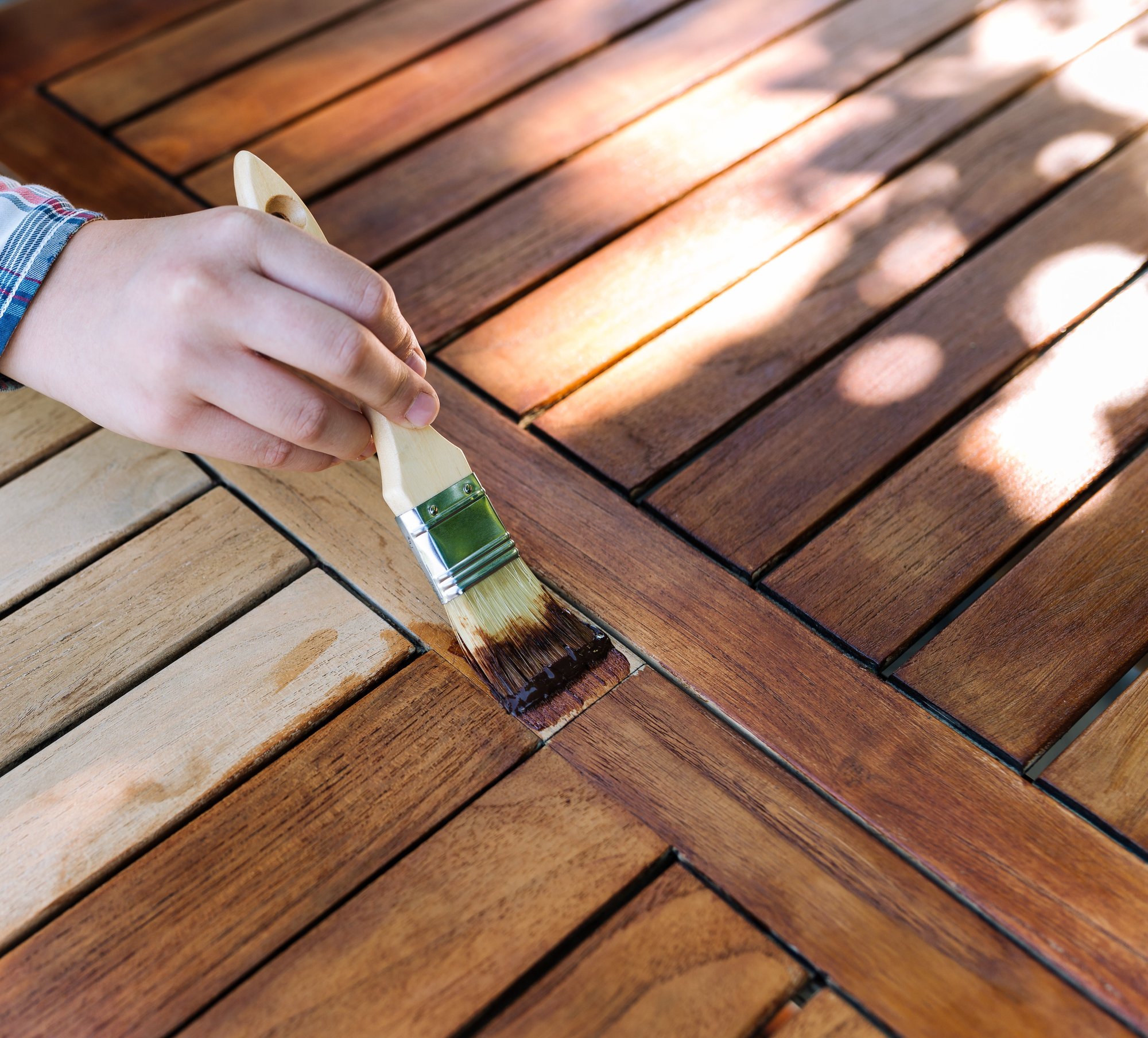 painting wood in flannel shirt